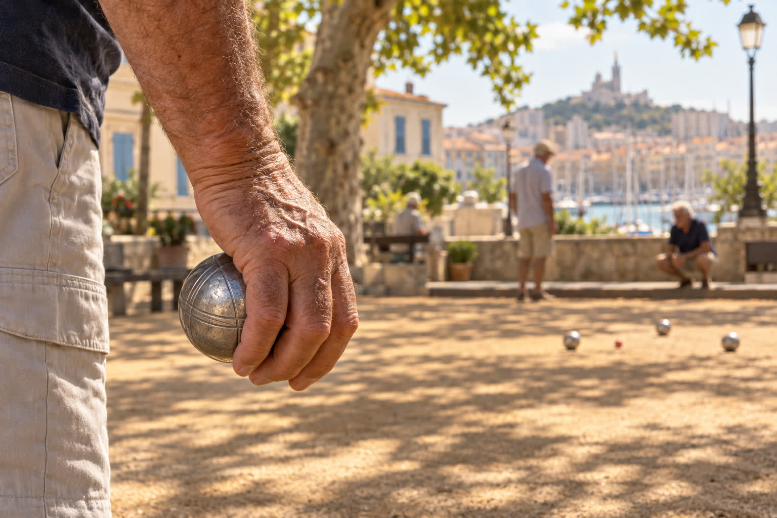 Main serrant une boule de pétanque striée, prête à pointer